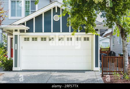 Porta White Garage con vialetto a Vancouver, Canada. Porta del garage in una casa di lusso. Vista esterna dell'immobile sulla facciata dell'hotel. Garage residenziale Do Foto Stock