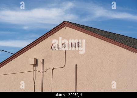 Scritta alpina rialzata e ombra sul lato timpano della stazione ferroviaria Amtrak, sotto il cielo blu Foto Stock