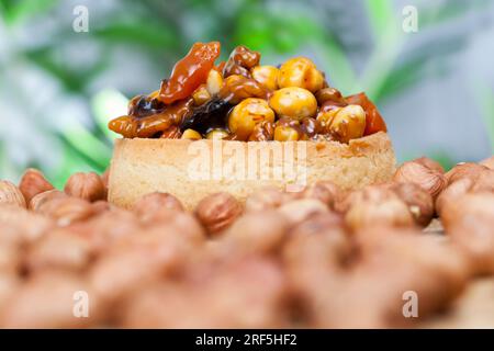 impastare le noci e la frutta secca ricoperta di caramello, piccola tartaruga rotonda con vari ripieni, croccante croccante con nocciole, arachidi e o Foto Stock