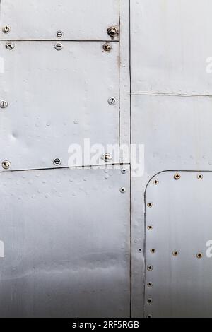 lamiere di alluminio unite tra loro mediante saldatura e rivettatura, primo piano di una parte del rivestimento esterno della fusoliera dell'aeromobile Foto Stock