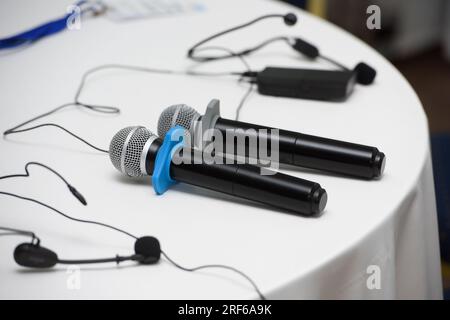 due microfoni su un tavolo rotondo. tovaglia bianca Foto Stock