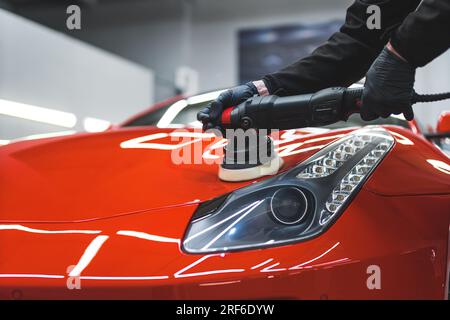 Pulizia meccanica dei fari e lucidatura con tampone di potenza in officina. Foto di alta qualità Foto Stock