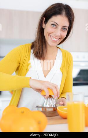 donna spremitura arance per il loro succo Foto Stock