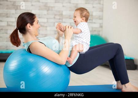 mamma donna che pratica yoga con suo figlio Foto Stock