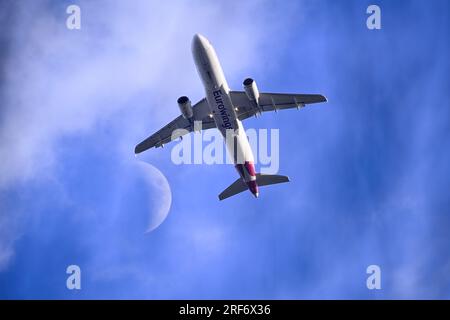 Passagierflugzeug der Fluggesellschaft Eurowings bei einem Rendezvous mit dem Mond über Hamburg, Deutschland Foto Stock