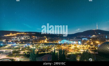 Tbilisi, Georgia. Paesaggio urbano notturno moderno. Vista panoramica serale del centro città Foto Stock