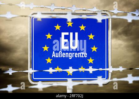 FOTOMONTAGE, EU-Schild mit Aufschrift Außengrenze und Stacheldraht Foto Stock