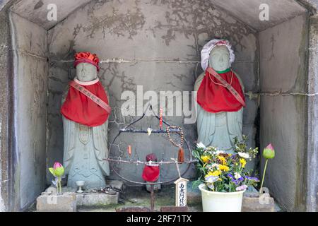 Statue in pietra (arte pubblica) di Ojizou san, protettore dei bambini e protettore dei viaggiatori, Giappone. TRADUZIONE: Il compassionevole Amitabha Buddha. Foto Stock