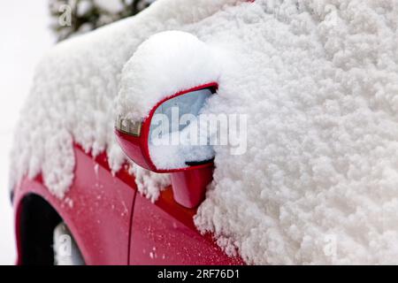 Ein eingeschneites rotes Auto im Winter, Schnee, Rad, Spiegel, Foto Stock