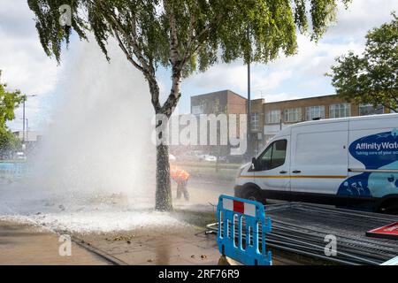 Stanmore, Greater London, Regno Unito. 1 agosto 2023. Principale principale d'acqua di scoppio lungo Honeypot Lane a doppia carreggiata a Stanmore, Greater London. Presenza di acqua di affinità. I detriti circondavano la principale dell'acqua di scoppio ed era presente un grande beccuccio. C'e' stata una grossa perdita d'acqua. In alcune immagini era presente un arcobaleno quando il sole illuminava il beccuccio dell'acqua. Un ventaglio d'acqua scorreva sotto e accanto alle vicine auto parcheggiate. Crediti: Stephen Bell/Alamy Live News Foto Stock