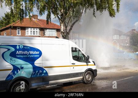 Stanmore, Greater London, Regno Unito. 1 agosto 2023. Principale principale d'acqua di scoppio lungo Honeypot Lane a doppia carreggiata a Stanmore, Greater London. Presenza di acqua di affinità. I detriti circondavano la principale dell'acqua di scoppio ed era presente un grande beccuccio. C'e' stata una grossa perdita d'acqua. In alcune immagini era presente un arcobaleno quando il sole illuminava il beccuccio dell'acqua. Un ventaglio d'acqua scorreva sotto e accanto alle vicine auto parcheggiate. Crediti: Stephen Bell/Alamy Live News Foto Stock