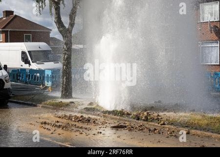 Stanmore, Greater London, Regno Unito. 1 agosto 2023. Principale principale d'acqua di scoppio lungo Honeypot Lane a doppia carreggiata a Stanmore, Greater London. Presenza di acqua di affinità. I detriti circondavano la principale dell'acqua di scoppio ed era presente un grande beccuccio. C'e' stata una grossa perdita d'acqua. In alcune immagini era presente un arcobaleno quando il sole illuminava il beccuccio dell'acqua. Un ventaglio d'acqua scorreva sotto e accanto alle vicine auto parcheggiate. Crediti: Stephen Bell/Alamy Live News Foto Stock