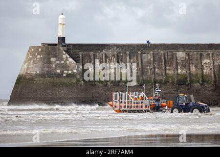 L'equipaggio della RNLI ritorna alla loro stazione a Sandy Bay, Porthcawl. Foto Stock