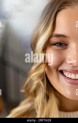 Ritratto di donna caucasica felice con lunghi capelli biondi a casa Foto Stock
