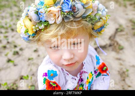 Una triste ragazza Ucraina con una corona e una camicia ricamata. Il bambino è un rifugiato dall'Ucraina. Ragazza che ha perso la casa Foto Stock