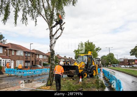 Stanmore, Greater London, Regno Unito. 1 agosto 2023. Altre immagini relative alla principale rete d'acqua di scoppio lungo Honeypot Lane a doppia carreggiata a Stanmore, Greater London. Presenza di acqua di affinità. Un escavatore JCB ha utilizzato la sua pala per limitare il flusso d'acqua fino a quando l'alimentazione idrica locale non poteva essere disattivata. Si sospettava che le radici di un albero nelle vicinanze potessero aver contribuito al principale dell'acqua di scoppio, quindi furono fatti i preparativi per rimuovere l'albero. Crediti: Stephen Bell/Alamy Live News Foto Stock