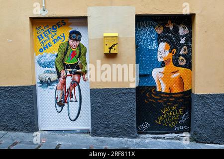 Arte di strada alle porte di un laboratorio di riparazione biciclette in un vicolo stretto ("caruggio") del centro storico, Genova, Liguria, Italia Foto Stock