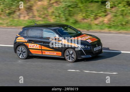 2021 Peugeot 208 GT Puretech S/S Puretech 100 Start/Stop Black Hatchback benzina 1200 cc. BSM, British School of Motoring, istruttore locale guida Learner driver car. Formazione autostradale del discente, istruzione, scuola guida, conducenti, lezioni di guida, Istruttore di guida autorizzato, istruttore supervisionato; cartelli stradali stradali su veicoli in movimento; viaggia a velocità sostenuta sull'autostrada M6 a Greater Manchester, Regno Unito Foto Stock