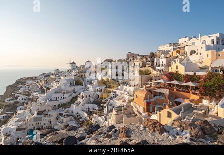 Case, ville e mulino a vento sul lato della scogliera nel villaggio di Oia (Ia), come si vede dal castello di Kasteli, Santorini, Grecia Foto Stock