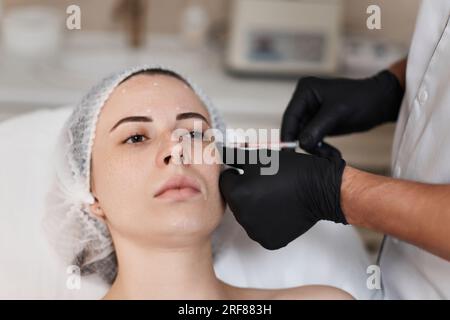 la donna riceve un'iniezione cosmetica di botox in faccia. Foto Stock