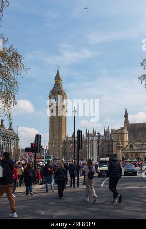 Londra, Regno Unito, 2023. Nella giornata della Terra, i manifestanti camminano verso Parliament Square, con il Big Ben e Westminster sullo sfondo (verticale) Foto Stock