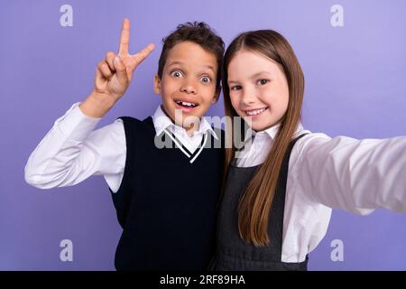 Foto del selfie di blogging di scolari positivi che rendono V sign isolato su sfondo dai colori vivaci Foto Stock