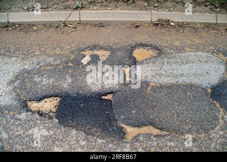 Stoke Poges, Regno Unito. 1 agosto 2023. Parte della superficie stradale sulla B416, Stoke Road a Stoke Poges, nel Buckinghamshire, ha fallito di nuovo. Anche alcuni scarichi sulla strada sono pieni di fango. Un gran numero di veicoli pesanti utilizza la strada per i lavori di costruzione del nuovo South Bucks Country Park, che si sta sviluppando vicino alla A416 appena fuori Slough, sul sito della vecchia Lanes Golf Academy. Il parco di campagna di 59 ettari sarà aperto al pubblico nel 2024. Si ritiene che una parte del materiale rovinato scaricato nel sito sia stata rovinata dai controversi tunnel della ferrovia ad alta velocità HS2, che sono in fase di realizzazione Foto Stock