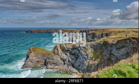 Un paesaggio panoramico che mostra l'aspra costa selvaggia di Bedruthan Steps, Cornovaglia, Inghilterra che incontra l'atlantico blu in una splendida giornata estiva. Foto Stock