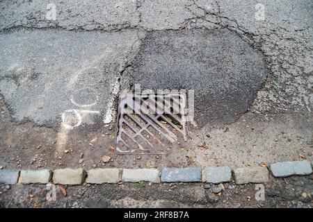 Stoke Poges, Regno Unito. 1 agosto 2023. Parte della superficie stradale sulla B416, Stoke Road a Stoke Poges, nel Buckinghamshire, ha fallito di nuovo. Anche alcuni scarichi sulla strada sono pieni di fango. Un gran numero di veicoli pesanti utilizza la strada per i lavori di costruzione del nuovo South Bucks Country Park, che si sta sviluppando vicino alla A416 appena fuori Slough, sul sito della vecchia Lanes Golf Academy. Il parco di campagna di 59 ettari sarà aperto al pubblico nel 2024. Si ritiene che una parte del materiale rovinato scaricato nel sito sia stata rovinata dai controversi tunnel della ferrovia ad alta velocità HS2, che sono in fase di realizzazione Foto Stock