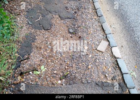 Stoke Poges, Regno Unito. 1 agosto 2023. Parte della superficie stradale sulla B416, Stoke Road a Stoke Poges, nel Buckinghamshire, ha fallito di nuovo. Anche alcuni scarichi sulla strada sono pieni di fango. Un gran numero di veicoli pesanti utilizza la strada per i lavori di costruzione del nuovo South Bucks Country Park, che si sta sviluppando vicino alla A416 appena fuori Slough, sul sito della vecchia Lanes Golf Academy. Il parco di campagna di 59 ettari sarà aperto al pubblico nel 2024. Si ritiene che una parte del materiale rovinato scaricato nel sito sia stata rovinata dai controversi tunnel della ferrovia ad alta velocità HS2, che sono in fase di realizzazione Foto Stock