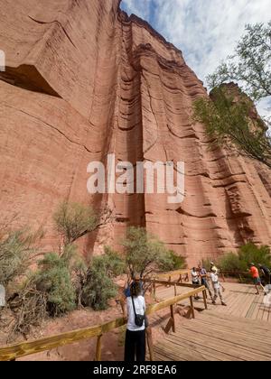 Turisti al Chimney, un canale eroso nel muro di arenaria della gola di Talampaya, Parco Nazionale di Talampaya in Argentina. Foto Stock