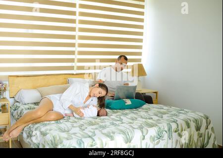 Famiglia con bambino in camera da letto Foto Stock