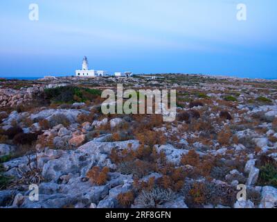 Un faro sull'isola di Minorca circondato da un terreno roccioso. Un faro de la Isla de Menorca rodeado de un terreno pedregoso. Foto Stock