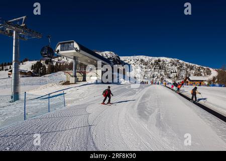 Falcade, Italia - 15 febbraio 2023: Stazione a monte di un impianto di risalita sulle montagne delle Dolomiti. Cabina di arrivo per gli impianti di risalita in cima alla montagna. In alto Foto Stock