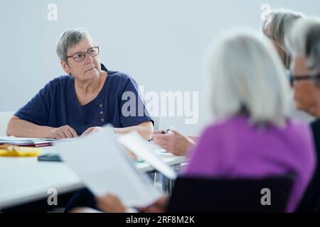 Ludwigshafen, Germania. 7 giugno 2023. L'organizzatrice e "Reading leader" Julia Szostek (l) discute con i partecipanti presso la biblioteca comunale. La lettura condivisa è un modo leggermente diverso di leggere insieme. Un esperto leader della lettura porta un racconto breve e una poesia e legge ad alta voce. Durante le pause di lettura, c'è tempo per condividere e ascoltare. Crediti: Uwe Anspach/dpa/Alamy Live News Foto Stock