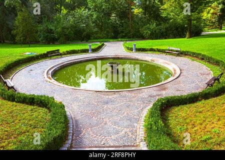 Uman. Il parco Sofievsky di mattina. Fontana con panchine. Foto Stock