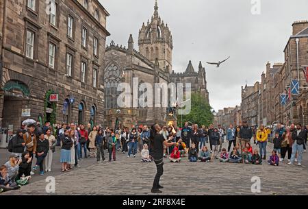 Royal Mile, High Street, Edimburgo, Scozia, Regno Unito. 1 agosto 2023. Chiunque camminasse per High Street avrebbe potuto credere che il Festival Fringe ufficiale di Edimburgo fosse già iniziato quando un grande pubblico cosmopolita si riunì per guardare gli artisti di strada professionisti all'ora del tè. Nella foto: Kozo Kaos intrattiene il pubblico con il suo spettacolo di giocoliere con il fuoco. Credito: AWhite/alamy live news. Foto Stock