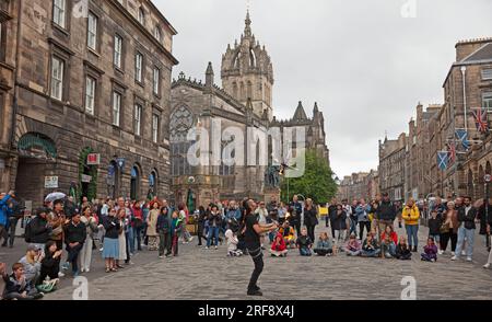 Royal Mile, High Street, Edimburgo, Scozia, Regno Unito. 1 agosto 2023. Chiunque camminasse per High Street avrebbe potuto credere che il Festival Fringe ufficiale di Edimburgo fosse già iniziato quando un grande pubblico cosmopolita si riunì per guardare gli artisti di strada professionisti all'ora del tè. Nella foto: Kozo Kaos intrattiene il pubblico con il suo spettacolo di giocoliere con il fuoco. Credito: AWhite/alamy live news. Foto Stock