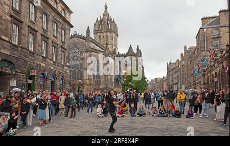 Royal Mile, High Street, Edimburgo, Scozia, Regno Unito. 1 agosto 2023. Chiunque camminasse per High Street avrebbe potuto credere che il Festival Fringe ufficiale di Edimburgo fosse già iniziato quando un grande pubblico cosmopolita si riunì per guardare gli artisti di strada professionisti all'ora del tè. Nella foto: Kozo Kaos intrattiene il pubblico con il suo spettacolo di giocoliere con il fuoco. Credito: AWhite/alamy live news. Foto Stock