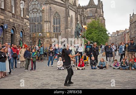 Royal Mile, High Street, Edimburgo, Scozia, Regno Unito. 1 agosto 2023. Chiunque camminasse per High Street avrebbe potuto credere che il Festival Fringe ufficiale di Edimburgo fosse già iniziato quando un grande pubblico cosmopolita si riunì per guardare gli artisti di strada professionisti all'ora del tè. Nella foto: Kozo Kaos intrattiene il pubblico con il suo spettacolo di giocoliere con il fuoco. Credito: AWhite/alamy live news. Foto Stock