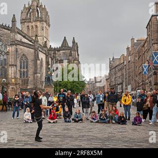 Royal Mile, High Street, Edimburgo, Scozia, Regno Unito. 1 agosto 2023. Chiunque camminasse per High Street avrebbe potuto credere che il Festival Fringe ufficiale di Edimburgo fosse già iniziato quando un grande pubblico cosmopolita si riunì per guardare gli artisti di strada professionisti all'ora del tè. Nella foto: Kozo Kaos intrattiene il pubblico con il suo spettacolo di giocoliere con il fuoco. Credito: AWhite/alamy live news. Foto Stock