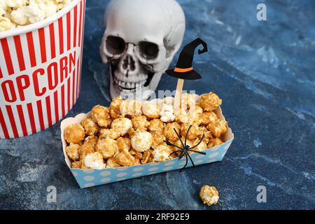 Secchiello con gustosi popcorn, teschio e biglietti per il cinema al tavolo  grigio. Festa di Halloween Foto stock - Alamy