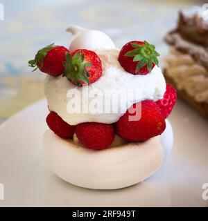 Pavlova alla fragola individuale su un piatto bianco Foto Stock