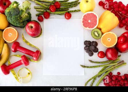 Carta con spazio per la copia, frutta, frutti di bosco, verdura e manubri, metro a nastro Foto Stock