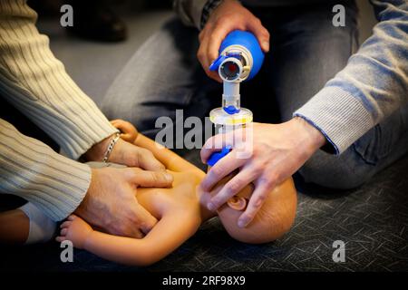 Addestramento di pronto soccorso: Uso di una sacca per rianimatore manuale su un manichino infantile. Foto Stock