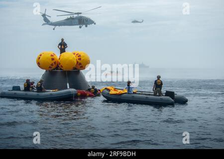 San Diego, California, USA. 1 agosto 2023. Elicotteri navali dell'Helicopter Sea Combat Squadron (HSC) 23 wildcard sorvolano l'Orion Crew Module test Article (CMTA) con bandiere americane dopo aver completato le operazioni durante una simulazione di missione Artemis II durante il test di recupero 10 (URT-10) della NASA al largo della costa di San Diego. Durante il test, la squadra ha praticato come estrarre i quattro astronauti che si avventureranno intorno alla Luna dalla loro navicella spaziale dopo l'atterraggio nell'Oceano Pacifico, e recuperare il modulo dell'equipaggio Orion. Credito: NASA/ZUMA Press Wire/ZUMAPRESS.com/Alamy Live News Foto Stock