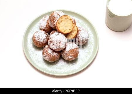 Carnevale del giovedì grasso piatto o Tlusty Czwartek, tradizione cristiana. Zeppole o Paczki su piatto con zucchero in polvere, tazza di latte sul tavolo. Doughnut Foto Stock