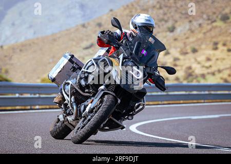motociclista che prende una curva affilata sulla sua moto. Fotografia scattata nel porto di Navalmoral, provincia della città di Avila, Spagna, durante il giorno Settem Foto Stock