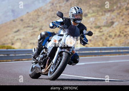 motociclista che prende una curva affilata sulla sua moto. Fotografia scattata nel porto di Navalmoral, provincia della città di Avila, Spagna, durante il giorno Settem Foto Stock