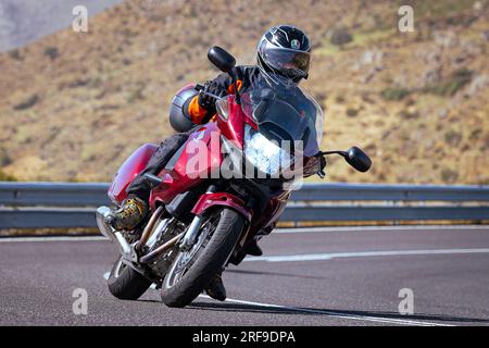 motociclista che prende una curva affilata sulla sua moto. Fotografia scattata nel porto di Navalmoral, provincia della città di Avila, Spagna, durante il giorno Settem Foto Stock